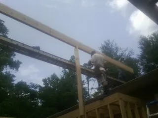 Carpenter setting a ridge beam over a new addition frame — Ice Dam Removal by Roofing Brothers in Lovejoy