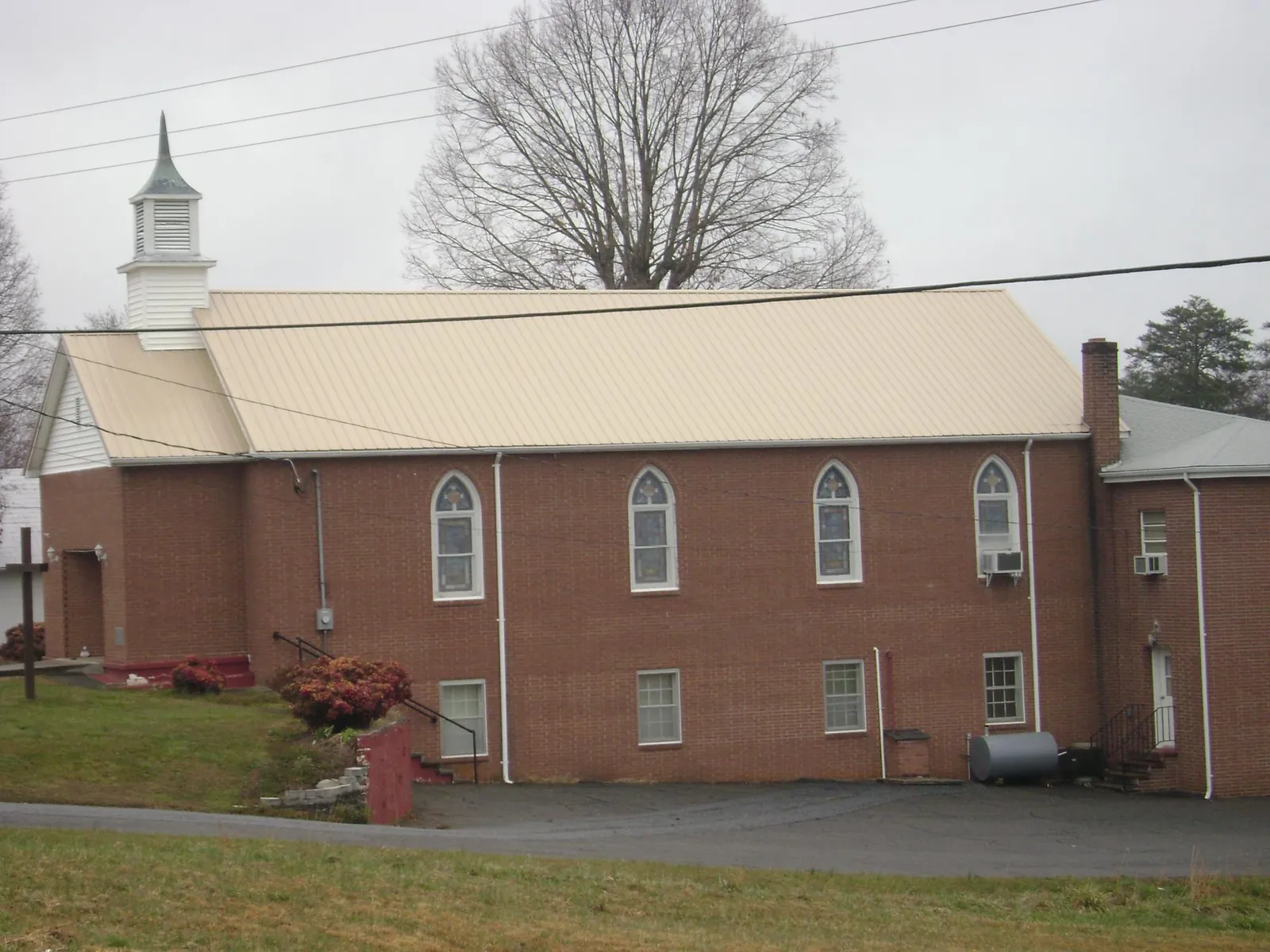 New tan metal roof on a brick church with a white steeple in Lovejoy