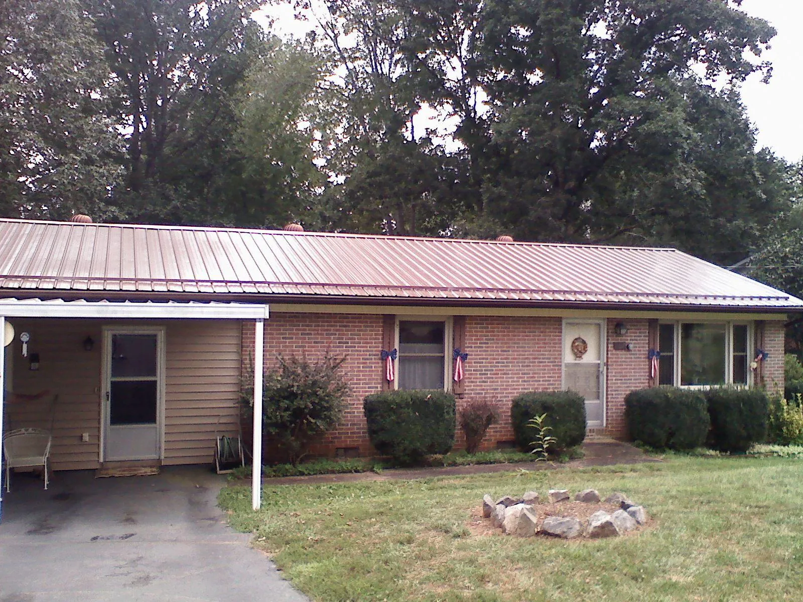 Bronze metal roof and carport on a brick ranch home — Roof Repair work by our crew in Lovejoy